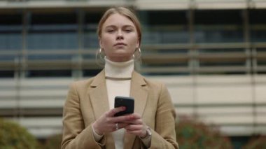 Elinde akıllı telefonla poz veren iş kadını portresi