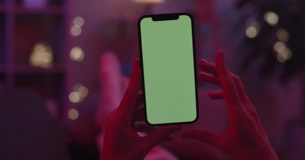 Vrouwelijke handen houden mobiele telefoon en tikken op groen scherm — Stockvideo