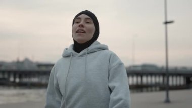 Yorgun Müslüman kadın sabah koşusunda mola veriyor.