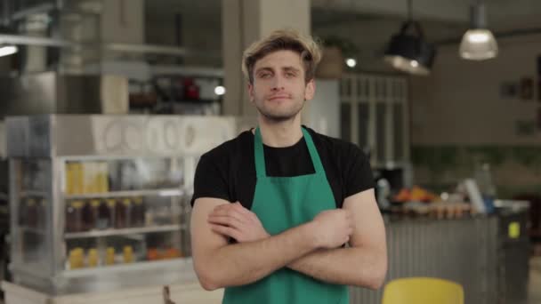 Tjener i forklæde stående på restaurant med krydsede hænder – Stock-video