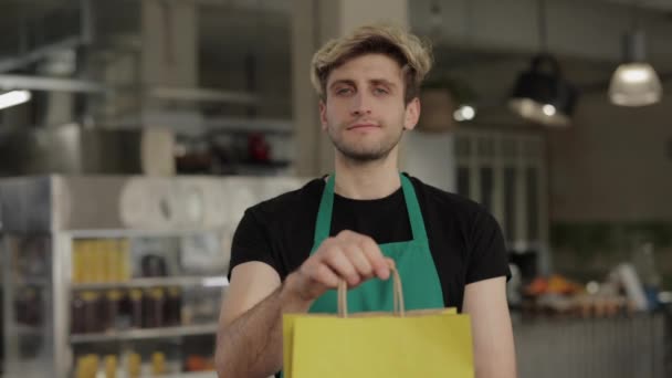 Bolsa de mano de camarero positiva con comida para llevar en la cafetería — Vídeos de Stock