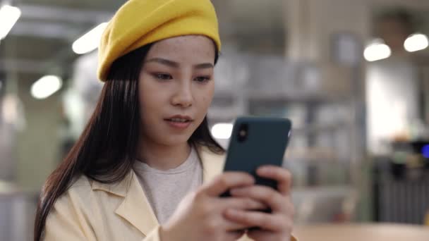 카페에서 스마트폰으로 메시지를 입력하는 아시아 여성 — 비디오