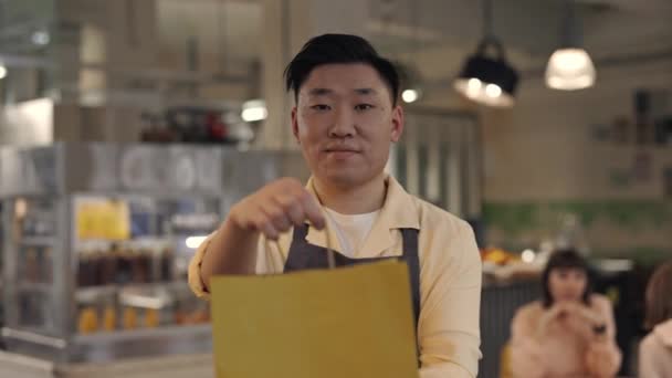 Retrato de camarero asiático en delantal preparando comida para llevar — Vídeos de Stock