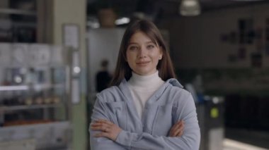 Kendi kafesinde kollarını kavuşturmuş çekici bir kadın.