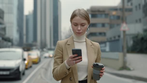 Señora de negocios con móvil y café en las manos al aire libre — Vídeos de Stock