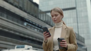 Akıllı telefonu ve kahvesi olan bir iş kadını.