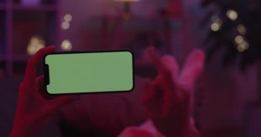 Yeşil ekranlı cep telefonunu tutan kadınların ellerini kapat