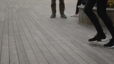 Spor taytlı kadın bacakları ve sokakta koşan spor ayakkabıları.