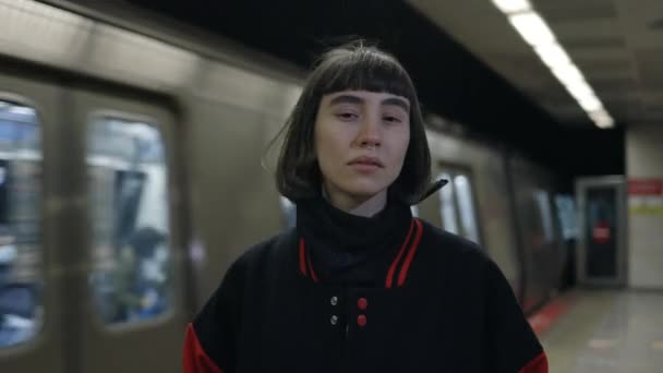 Kobieta z kolczykiem w nosie stoi na stacji metra — Wideo stockowe