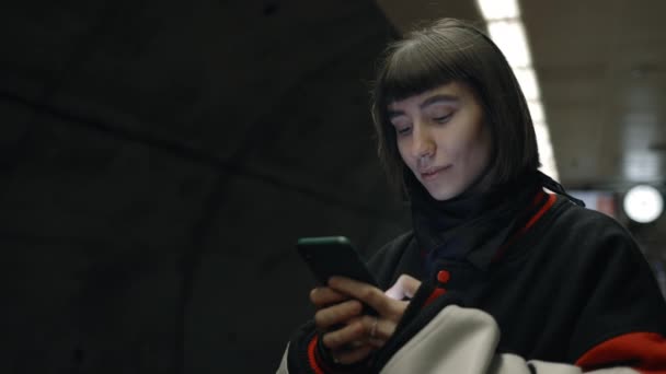 Привлекательная женщина с помощью смартфона в ожидании метро — стоковое видео