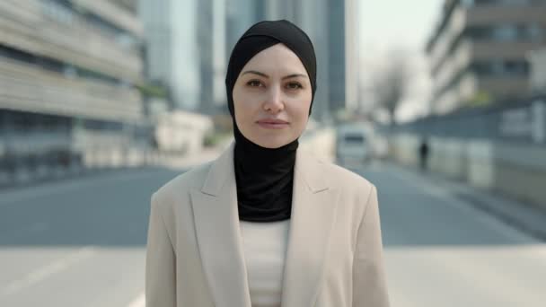 Positiv affärskvinna i hijab stående ensam på gatan — Stockvideo