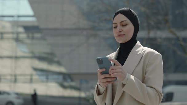 Muslimin surft im Freien mit Smartphone im Internet — Stockvideo