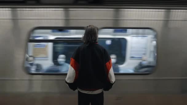 Vrouw op metrostation met rijdende trein voor — Stockvideo