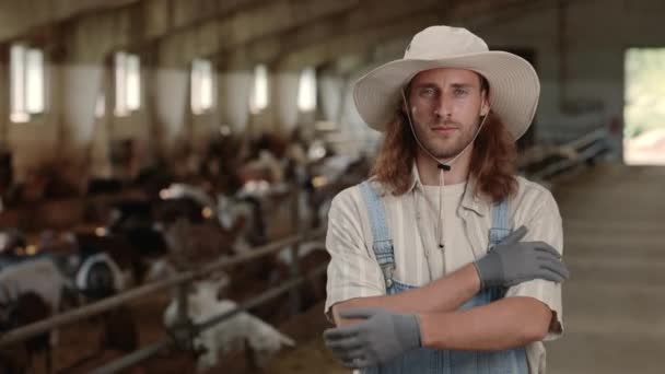 Junger Mann mit verschränkten Armen auf Bauernhof — Stockvideo
