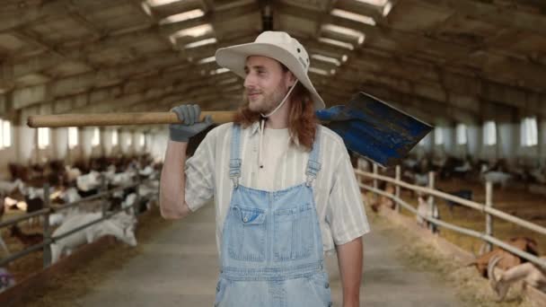 Junger Rotschopf steht mit Schaufel auf Ziegenfarm — Stockvideo