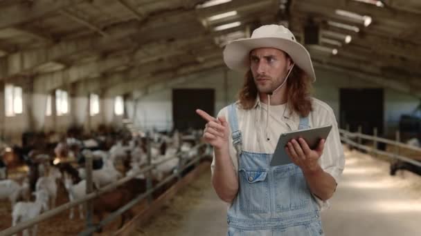 Fermier ciblé utilisant une tablette sur ranch avec des chèvres — Video