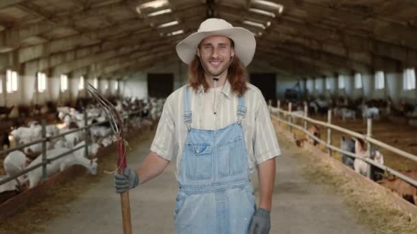 Éleveur caucasien en uniforme tenant fourche à la ferme — Video