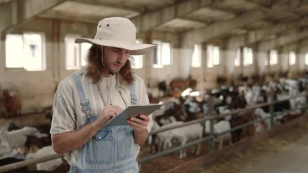 Agronomiste utilisant une tablette numérique tout en restant debout à la ferme de chèvres — Video
