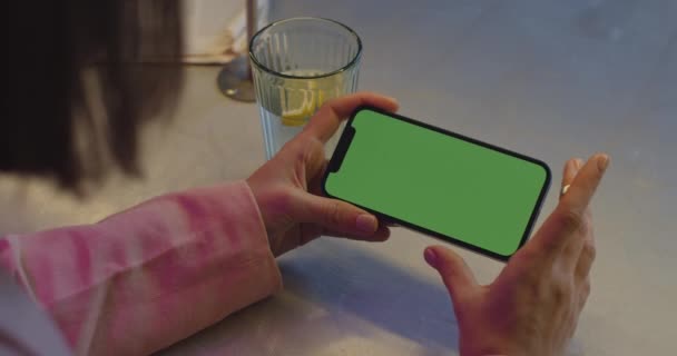 Mujer usando smartphone con pantalla de simulacro verde en la cafetería — Vídeos de Stock