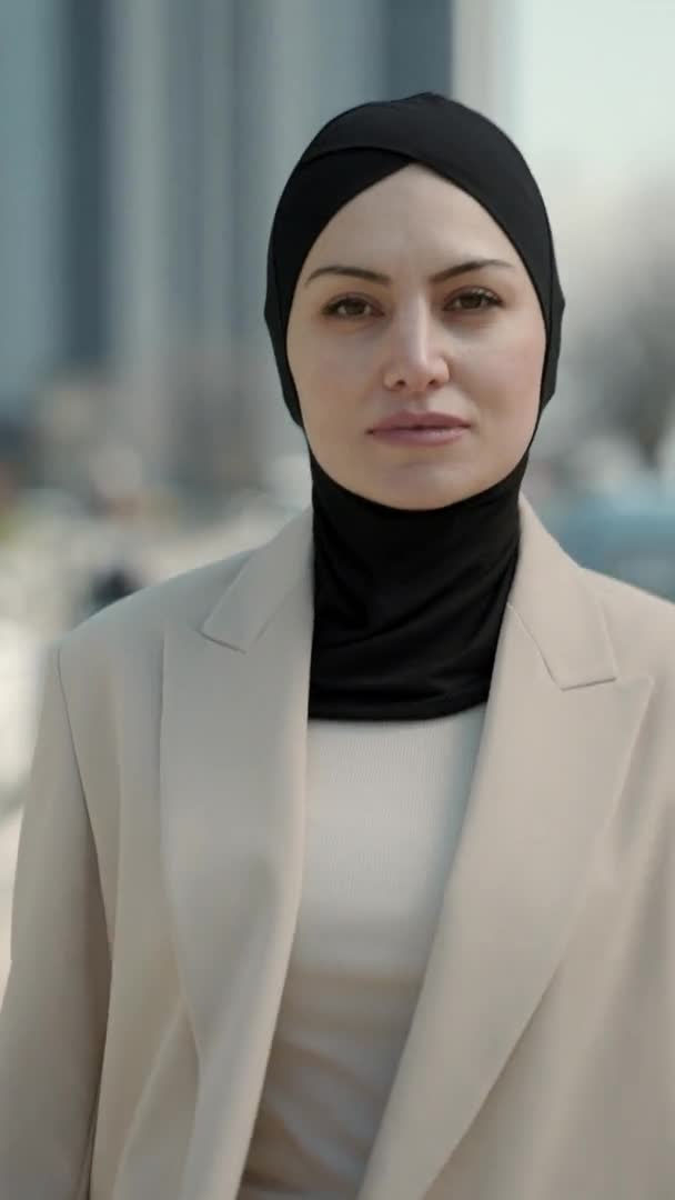 Vertikal video. Vacker affärskvinna i hijab går på gatan — Stockvideo