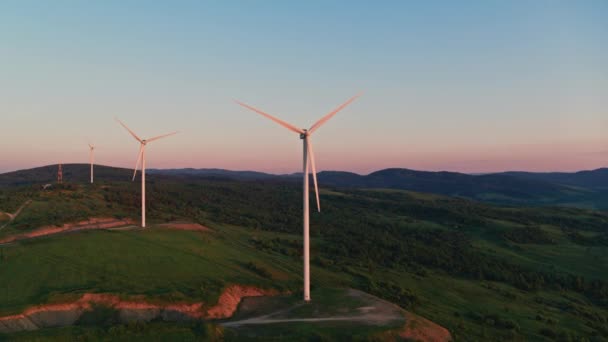Вид с воздуха на ветряные мельницы, стоящие на зеленом поле — стоковое видео