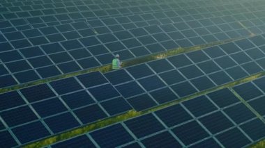 Güneş panellerini sahada gezen ve inceleyen mühendis