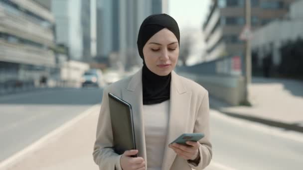 Арабская дама с планшетом и мобильной ходьбы по улице — стоковое видео