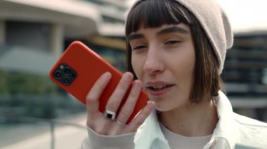 Ses iletisi kaydetmek için cep telefonu kullanan kadın müşteri