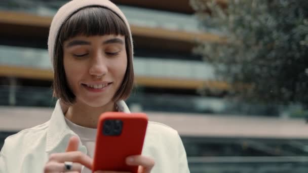 Femme debout près du centre commercial et tenant un téléphone portable — Video