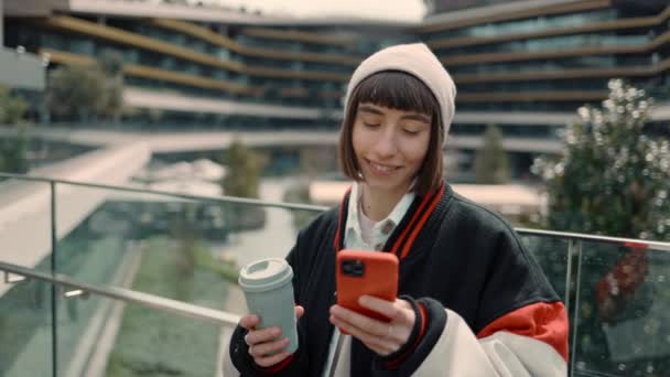Femeie elegantă cu smartphone și cafea lângă mall — Videoclip de stoc