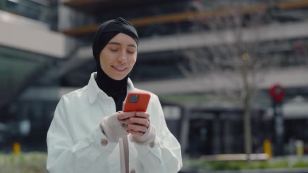 Hübsche Araberin im Hijab SMS auf dem Handy — Stockvideo