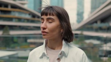 Smiling woman posing near huge shopping mall