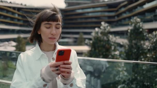 Kobieta z niespodzianką czytająca wiadomości na telefonie komórkowym — Wideo stockowe