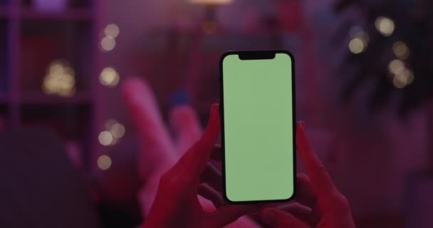 Närbild av kvinnliga händer som håller mobil med grön skärm — Stockvideo