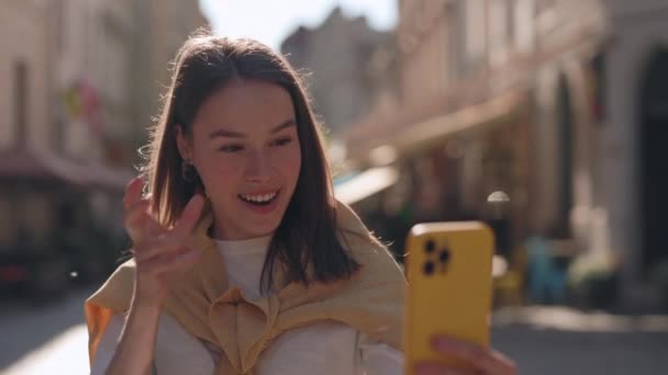 Усміхнена глуха жінка використовує мобільний для відеодзвінків на вулиці — стокове відео