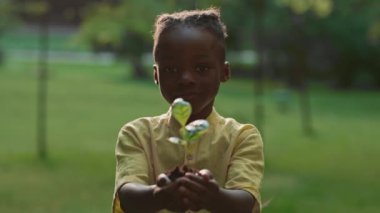 Afrikalı kız kamerada taze yeşil filizleniyor.
