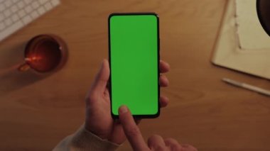 Yeşil boş ekranlı akıllı telefon kullanan adam