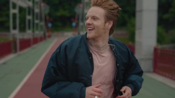 다리 위를 달리고 있는 붉은 머리를 한 조심 스러운 청년 — 비디오