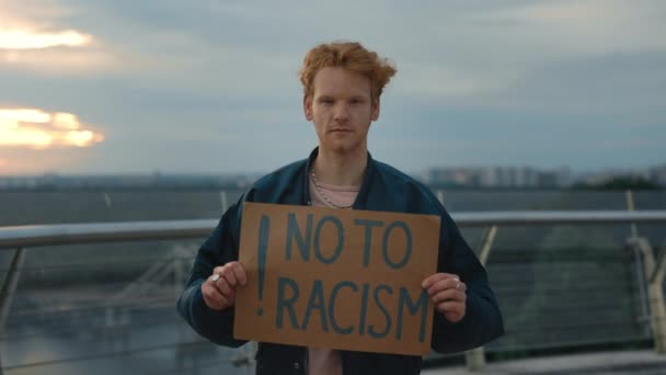 Рыжий держит картон со словами "нет" расизму — стоковое видео