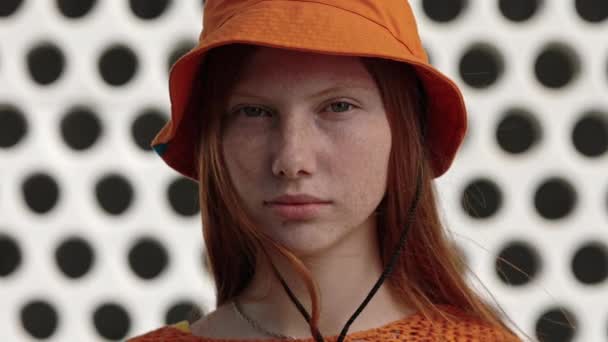 Pelirroja en naranja sombrero panama posando en la calle de la ciudad — Vídeos de Stock