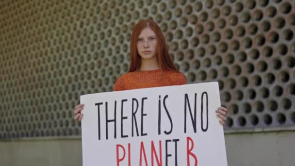 Девушка-подросток позирует на улице без транспаранта планеты Б — стоковое видео