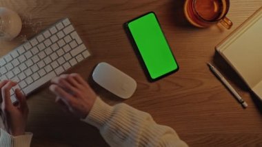 Yeşil ekran mobil kullanan ve klavyede yazan kadın