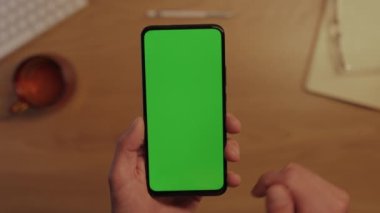 Modern akıllı telefonun yeşil boş ekranını tıklatan adam