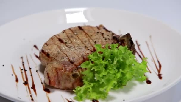 Filete de cerdo con hueso girando sobre fondo blanco — Vídeos de Stock