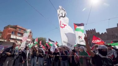 Rome, Italy, 5.10.2025: Demonstrators wave Palestinian and solidarity flags during a pro-Palestine rally near ancient walls in Rome, expressing unity, resistance, and support for Gaza.