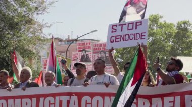 Rome, Italy, 5.10.2025: Protesters hold banners Stop Genocide during a pro-Palestine demonstration. Participants wave Palestinian flags and demand justice and solidarity with the people of Gaza.