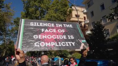 Rome, Italy, 5.10.2025: Protest sign reading Silence in the Face of Genocide is Complicity raised during a pro-Palestinian demonstration calling for awareness and justice.