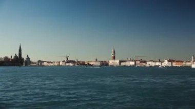 Gökyüzü Venedik gölünde, şehrin dönüm noktalarına karşı çeşitli gemiler ve tekneler yelken açıyor. St. Mark Campanile 'deki deniz limanında yoğun su taşımacılığı trafiği. Deniz sahnesi