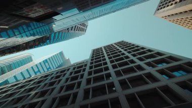 Hong Kong şehir merkezindeki modern cepheli ofis binaları arasında gölgeli bir sokak. Asya megapolis 'in modern iş bloğu mimari yapısı mavi gökyüzü altında