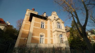 Kahverengi tuğlalardan oluşan eski bir bina ve beyaz klasik sıva, alçak açılı temiz gökyüzüne karşı. Tarihsel malikane, kentteki geçmişteki turistlerin ruhunu temsil ediyor.